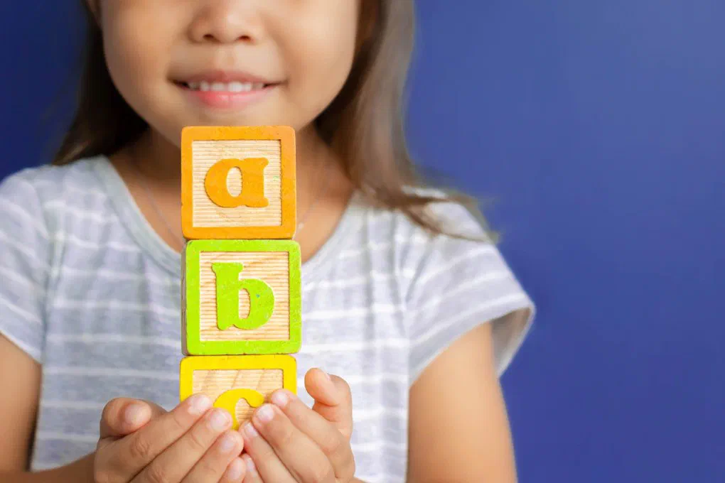 Alphabet blocks representing key childcare benefits terms for employers and HR