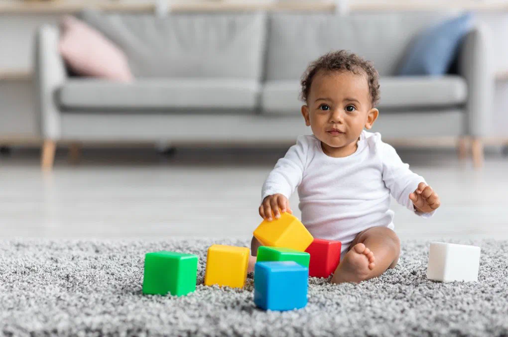 A baby playing safely with building blocks at a licensed home daycare