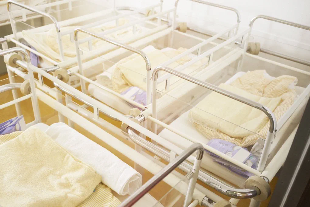 An empty hospital nursery highlighting gaps in traditional childcare benefits